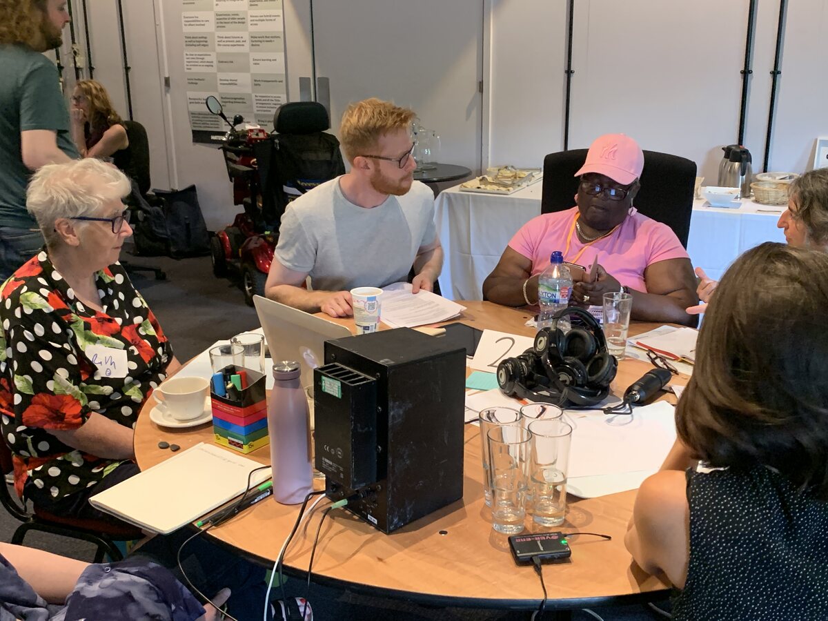 A group co-design workshop with participants sharing ideas around a table